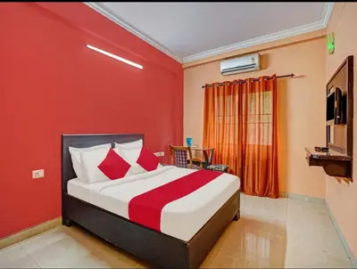 a bedroom with a bed and a red wall at Marhaba tourist home in Kunnamangalam