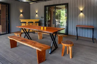 a wooden table and benches on a patio at Trumpet Deck in Kutta