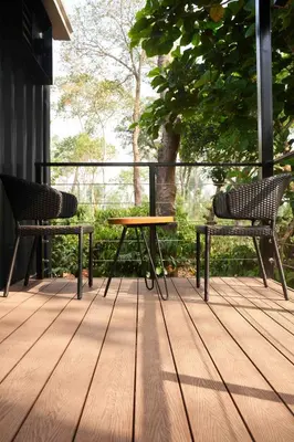 two chairs and a table on a wooden deck at Trumpet Deck in Kutta