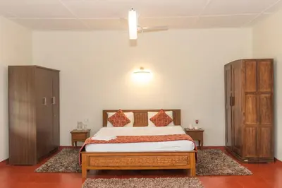 a bedroom with a bed and two cabinets in it at Villa Fair Winds, Sirukundra Estate in Vālpārai