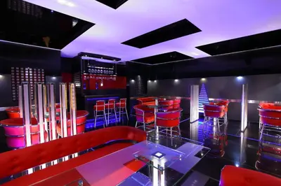 a bar with red chairs and a glass table at Hotel Luciya Palace in Trichūr