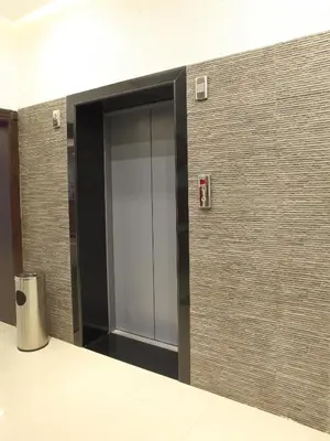 a hallway with an open door in a building at Hotel Luciya Palace in Trichūr