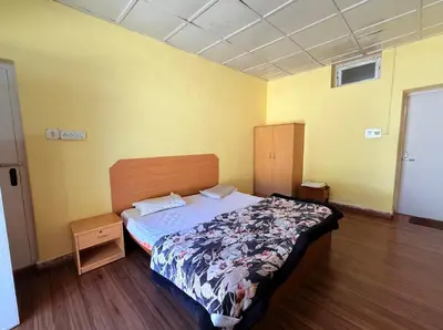 a bedroom with a bed and a wooden floor at Ubuntu Retreat - Aaram & Mukaam in Ooty