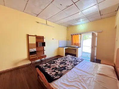 a bedroom with a bed and a desk and a mirror at Ubuntu Retreat - Aaram & Mukaam in Ooty