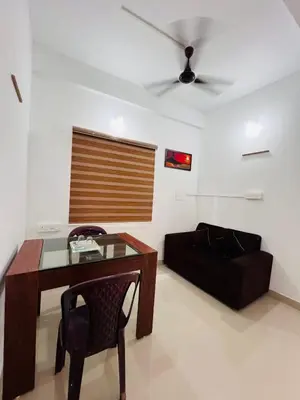 a living room with a table and a couch at SN RESiDENCY in Kozhikode