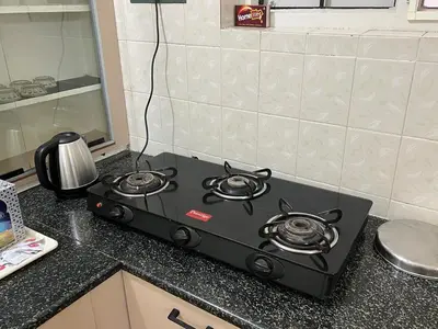 a stove top oven sitting on top of a kitchen counter at Akshaya - Charming 2BHK apartment with scenic view in Mysore