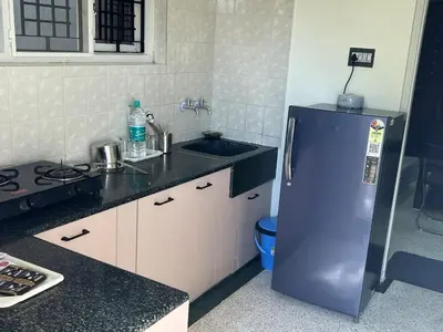 a kitchen with a blue refrigerator and a sink at Akshaya - Charming 2BHK apartment with scenic view in Mysore