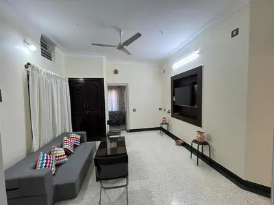 a living room with a couch and a flat screen tv at Akshaya - Charming 2BHK apartment with scenic view in Mysore