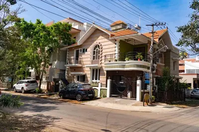 a house with a car parked in front of it at Akshaya - Charming 2BHK apartment with scenic view in Mysore