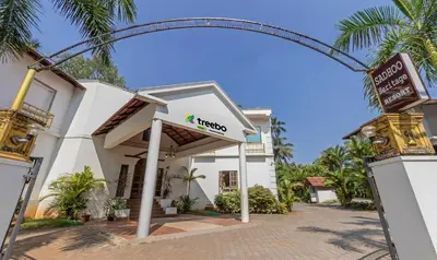 a sign for a hotel in front of a building at Treebo Sadhoo Heritage in Kannur