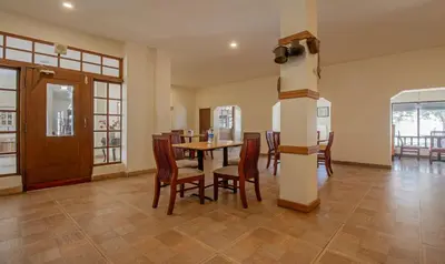 a dining room with a table and chairs at Treebo Sadhoo Heritage in Kannur
