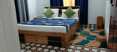 a bedroom with a wooden bed with pillows on it at Royal Valley Apartment in Kalpetta