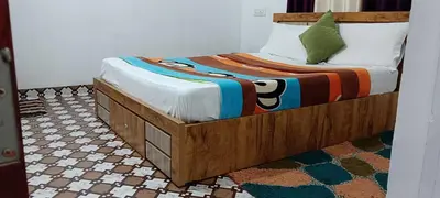 a bed with a wooden frame in a room at Royal Valley Apartment in Kalpetta