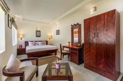 a bedroom with a bed and a desk and a table at Mango Hill Coimbatore-Near Isha Yoga in Alāndurai