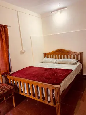 a bedroom with a wooden bed in a room at Nomadcasa Rooms in Kanthalloor