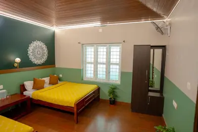 a bedroom with a yellow bed and green walls at Swastha Heritage Homestays Wayanad in Kaniyāmbetta