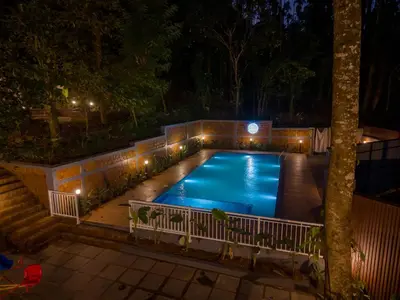 a swimming pool at night with lights at Swastha Heritage Homestays Wayanad in Kaniyāmbetta