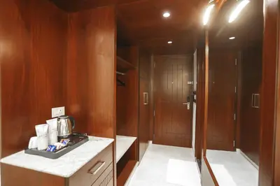 a room with a kitchen with wooden walls and a bathroom at Hotel Lakshmi Towers in Kāngayam