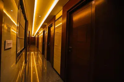 a hallway of a building with a door and lights at Hotel Lakshmi Towers in Kāngayam