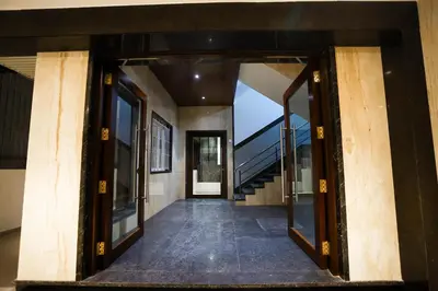 an open hallway of a house with glass doors at Hotel Lakshmi Towers in Kāngayam