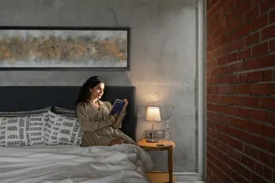 a woman sitting on a bed reading a book at LohonoStays Amani Villa 11A in Coonoor