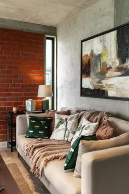 a living room with a couch and a brick wall at LohonoStays Amani Villa 11A in Coonoor