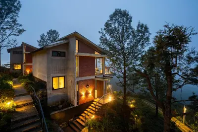 a house in the woods at night with lights at LohonoStays Amani Villa 11B in Coonoor