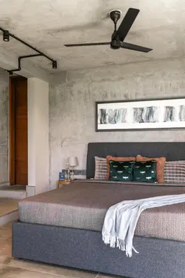 a bedroom with a large bed with a ceiling fan at LohonoStays Amani Villa 12A in Coonoor