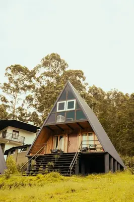 a house with a gambrel roof on a field at Eagle Woods Kookal in Kūkkāl