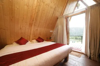 a bedroom with a bed and a large window at Eagle Woods Kookal in Kūkkāl