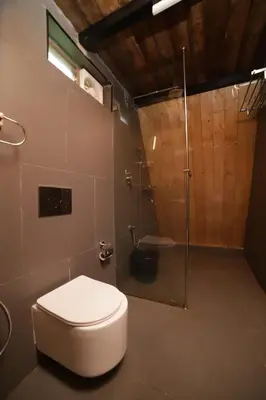 a bathroom with a toilet and a shower at Eagle Woods Kookal in Kūkkāl