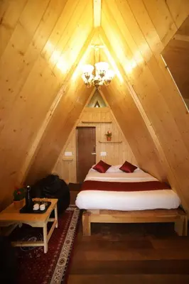 a bedroom with a bed in a wooden cabin at Eagle Woods Kookal in Kūkkāl