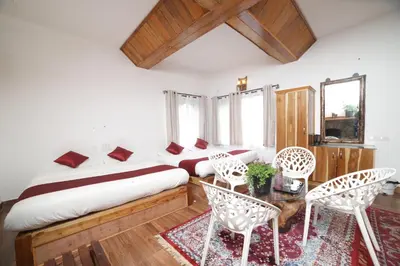 a bedroom with a bed and a table and chairs at Eagle Woods Kookal in Kūkkāl