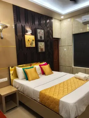 a bedroom with a large bed and a flat screen tv at Kappazha Tharavadu in Alwaye