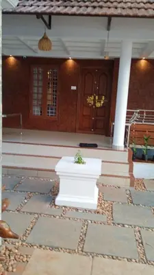 a front porch of a house with a potted plant at Kappazha Tharavadu in Alwaye