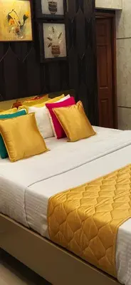 a large bed with colorful pillows on it at Paradise Homestay in Alwaye