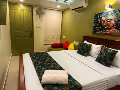 a bedroom with a large bed with a painting on the wall at Paradise Homestay in Alwaye