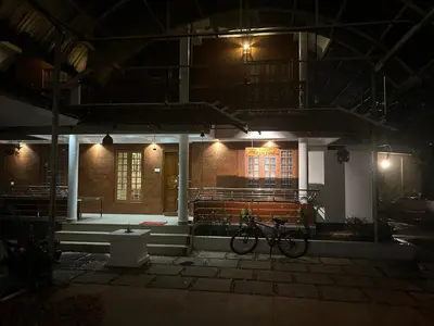 a bike parked in front of a building at night at Paradise Homestay in Alwaye