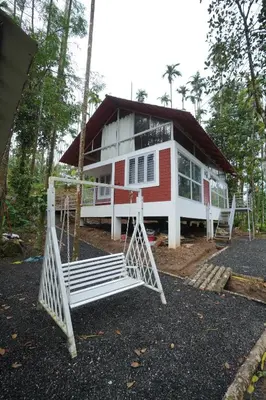a house with a swing in front of it at Areca Valley Farmstay in Agali
