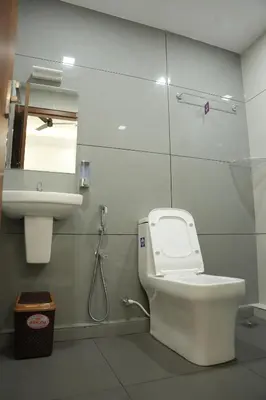 a bathroom with a toilet and a sink at Theeram Residency in Iringal