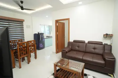 a living room with a couch and a table at Theeram Residency in Iringal