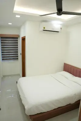 a bedroom with a white bed with a ceiling at Theeram Residency in Iringal