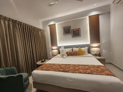 a bedroom with a large bed and a chair at VV's Lakshmi Inn in Thekkumkara