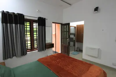 a bedroom with a bed and a window at Wayanad One in Wayanad