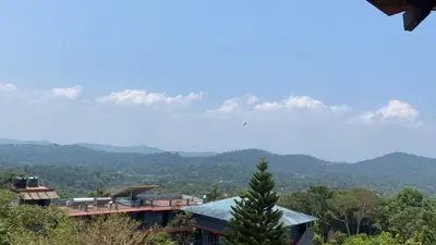 a view of a house with mountains in the background at View Point Stay Coorg in Madikeri