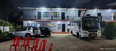 a bus parked in front of a building with red chairs at View Point Stay Coorg in Madikeri
