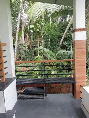 a bench in front of a window with plants at Izzath in Kottakkal