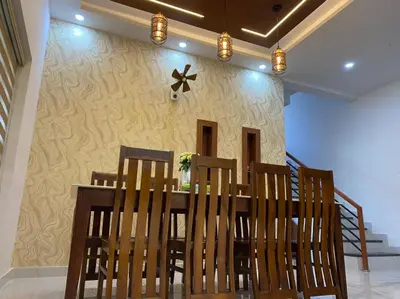 a dining room with a table and chairs at Izzath in Kottakkal