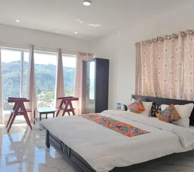 a bedroom with a large bed and a large window at THE DEW stay Three bedroom villa in Kodaikānāl