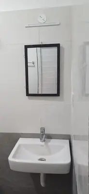 a bathroom with a white sink and a mirror at THE DEW stay Three bedroom villa in Kodaikānāl